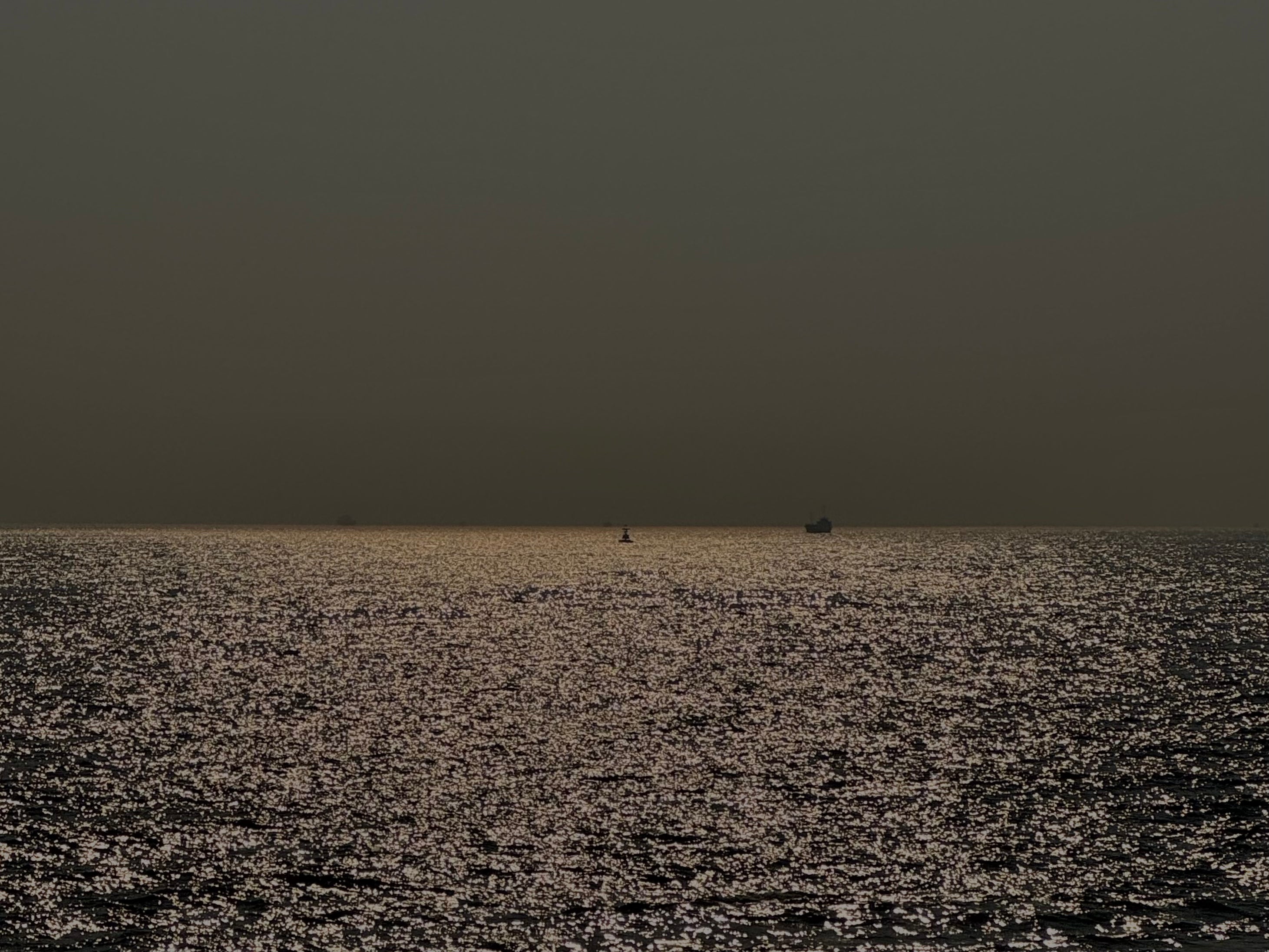 Sunlight sparkling on the ocean surface, waves shimmering under natural light.