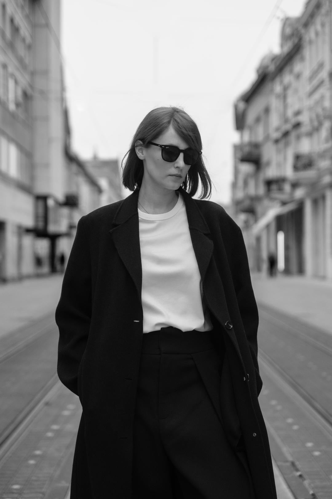A person wearing a white organic cotton unisex T-shirt by AURETEMPHE, styled in a minimal and modern look.