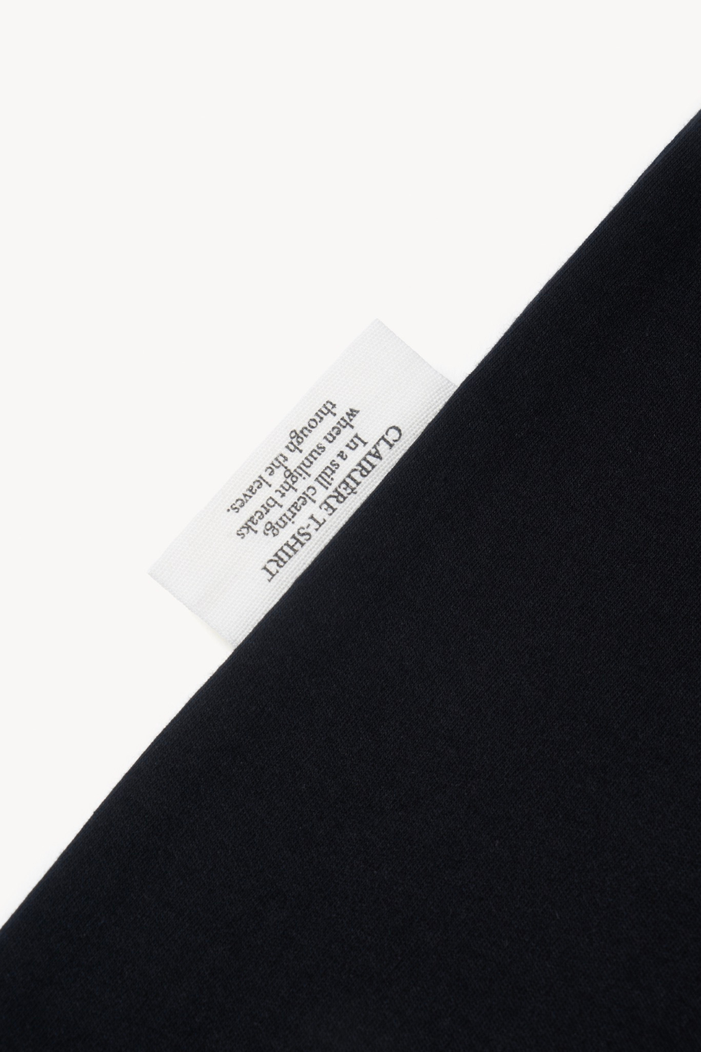 Detail of AURETEMPHE black long sleeve t-shirt showing its organic cotton side label.