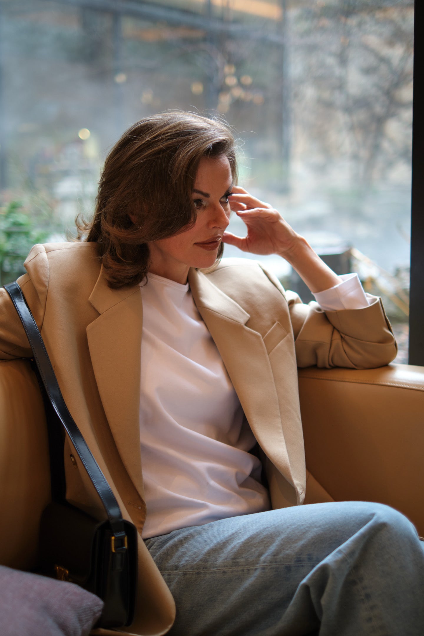 A person wearing a white long-sleeve organic cotton T-shirt, expressing a confident and elegant presence