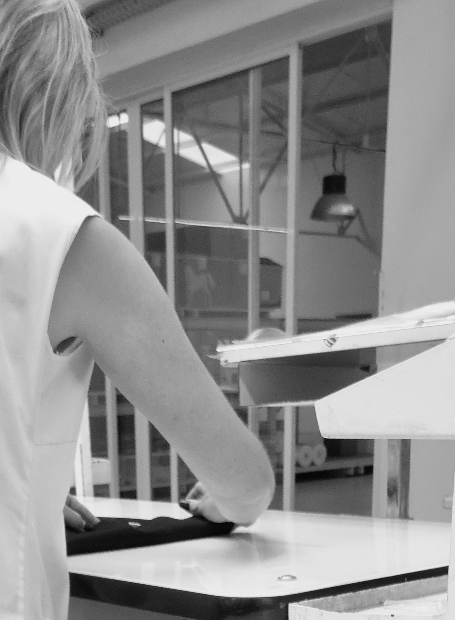 Detail of Portuguese craftsmanship: artisan folding completed AURETEMPHE organic cotton clothing.